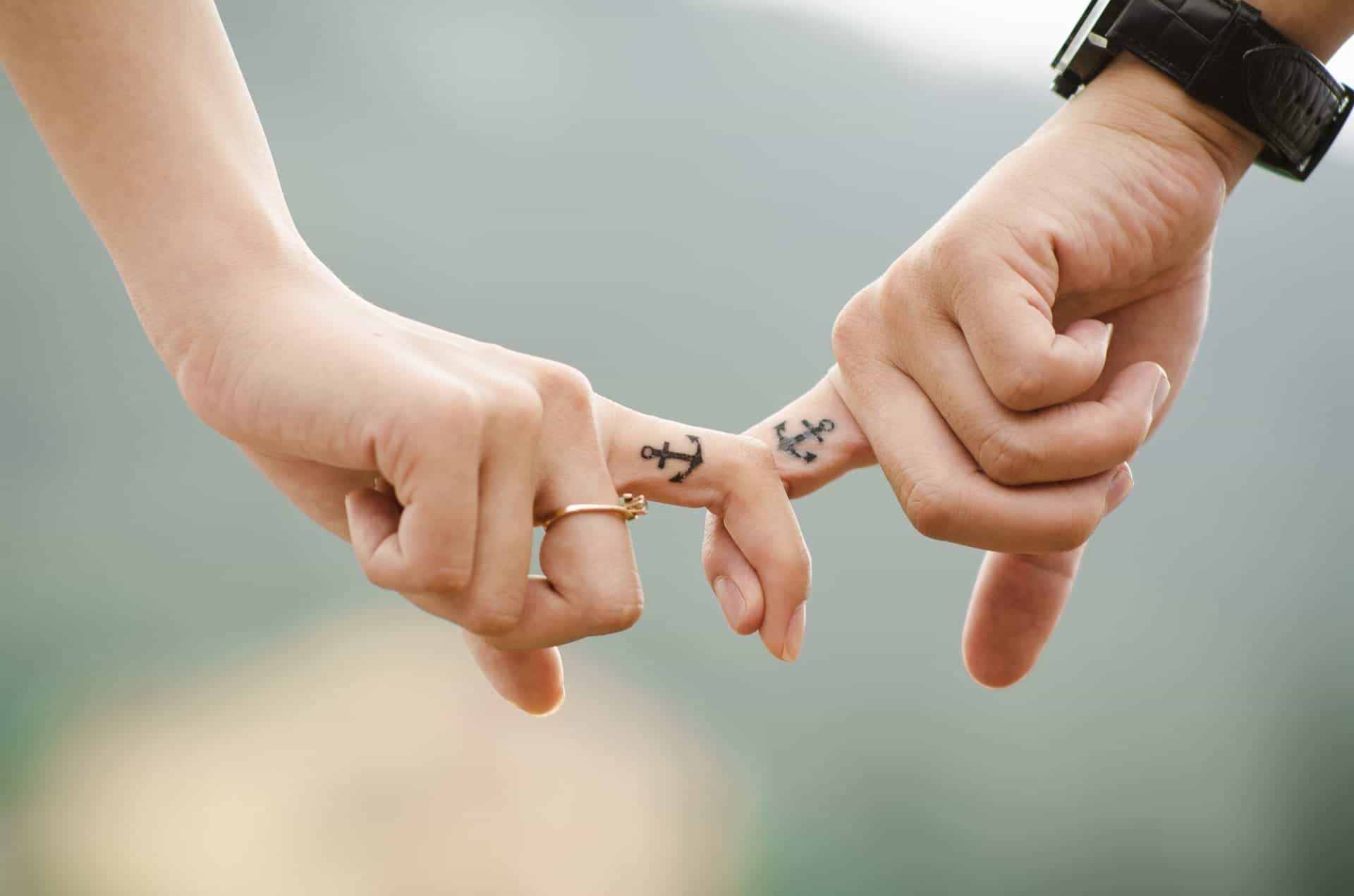 fingers-holding-hands-with-tattoos-pexels-photo-38870
